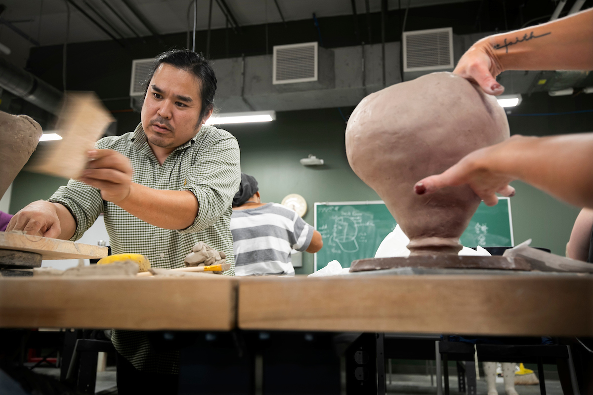 Ceramics instructor Kensuke Yamada teaching students in his introduction to pottery class.