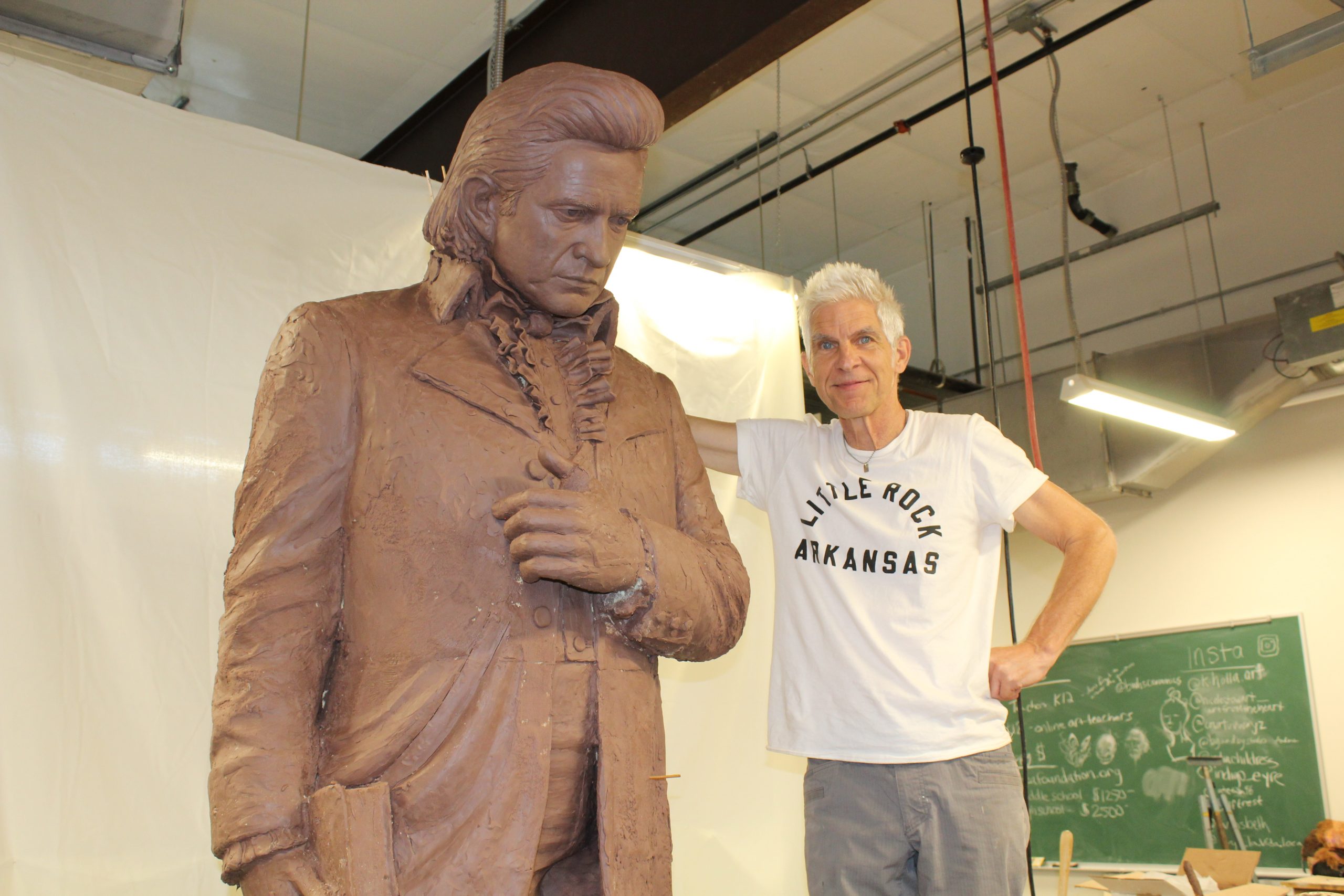 Artist and UA Little Rock Alumnus Kevin Kresse stands next to his model of the Johnny Cash sculpture while visiting UA Little Rock in 2022. Photo by Angie Faller.