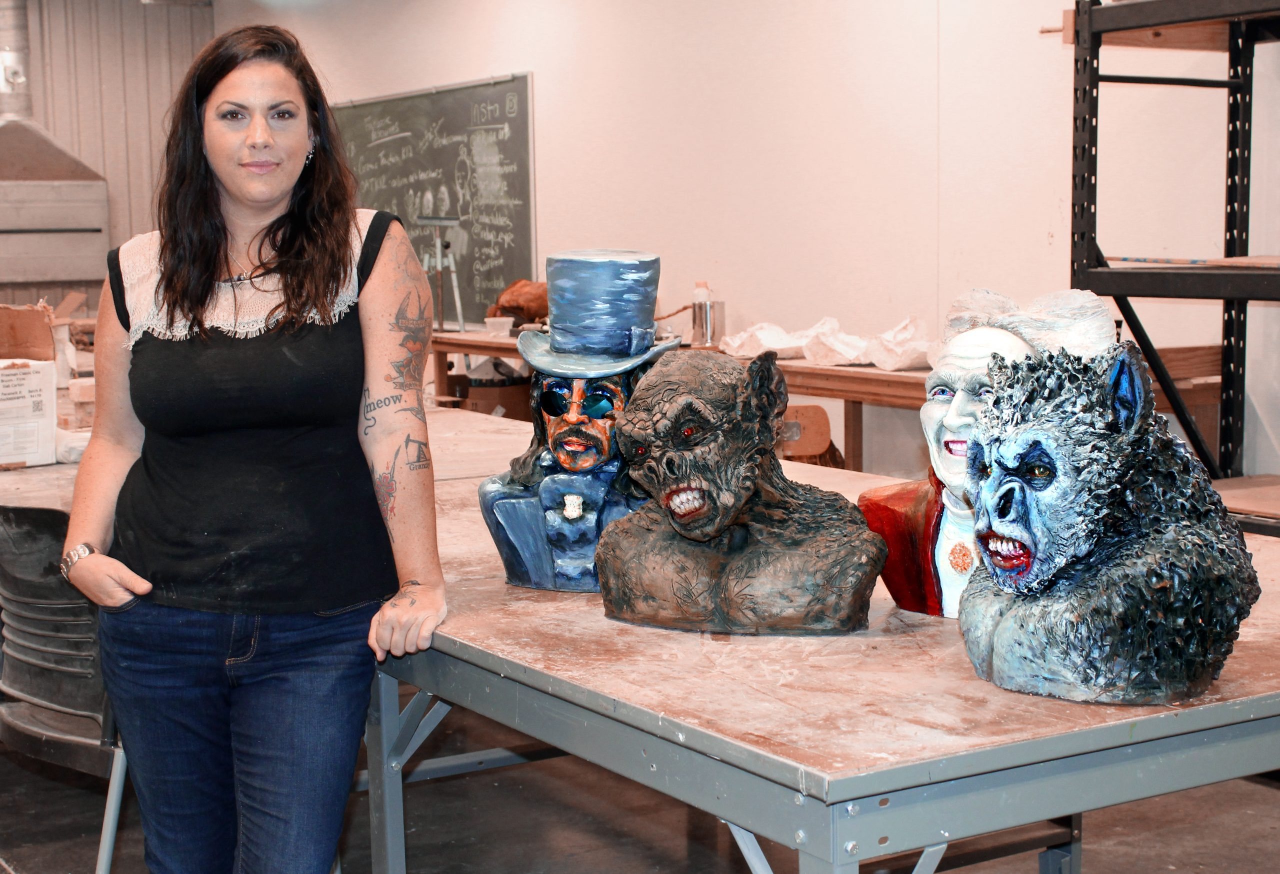 UA Little Rock art student Nicole Stewart stands alongside sculptures she has created at UA Little Rock. Photo by Angie Faller.