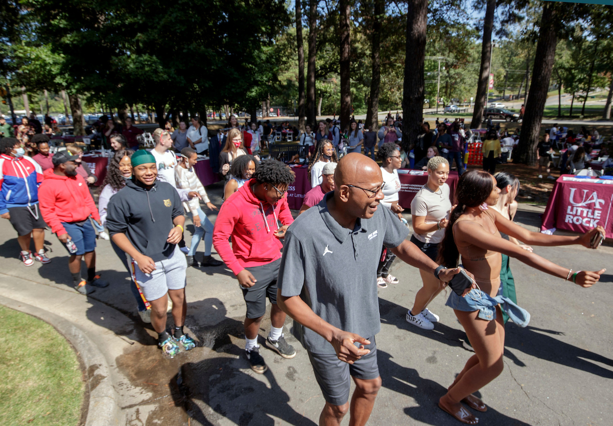 UA Little Rock men's basketball coach Darrell Walker dances with students at the annual BBQ at Baileys back-to-school picnic.