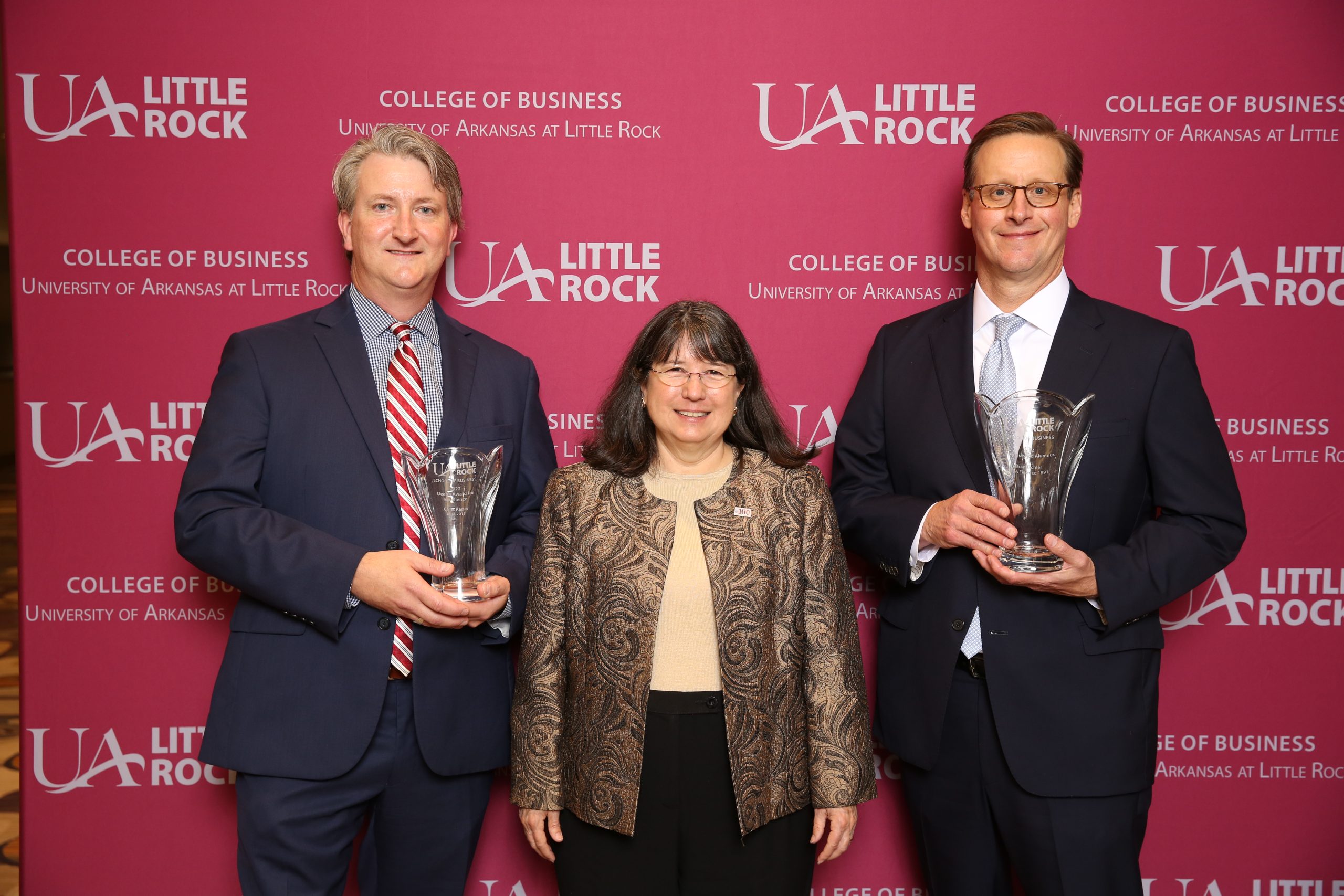 UA Little Rock Chancellor Christina Drale, middle, honors Brad Eichler as the School of Business Distinguished Alumnus of the Year and Chris Raper with the Dean’s Award for Excellence.