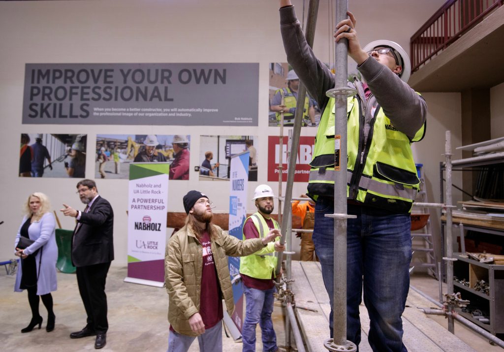 A UA Little Rock student practices erecting scaffolding in the newly dedicated Nabholz High Bay Lab. Photo by Ben Krain.