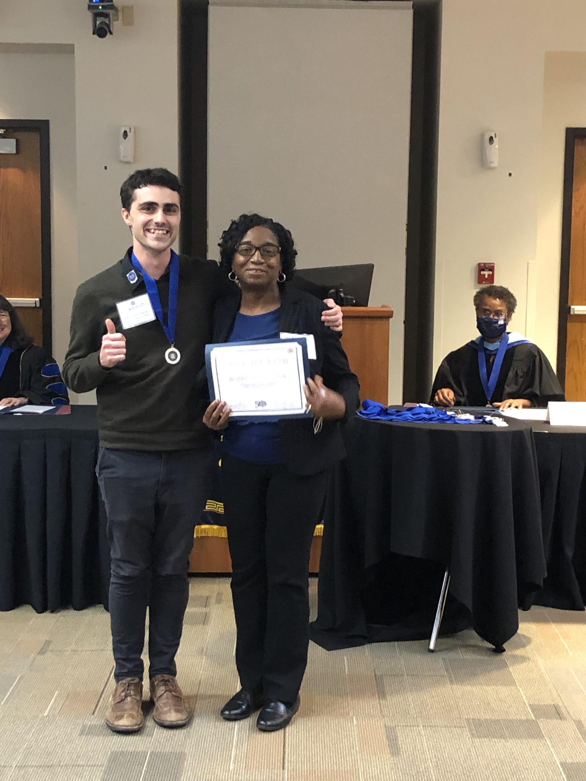 Connor Pearce, Phi Kappa Phi Grants and Awards Chair, presents Bobbie Handcock with the award for her inspiring essay.