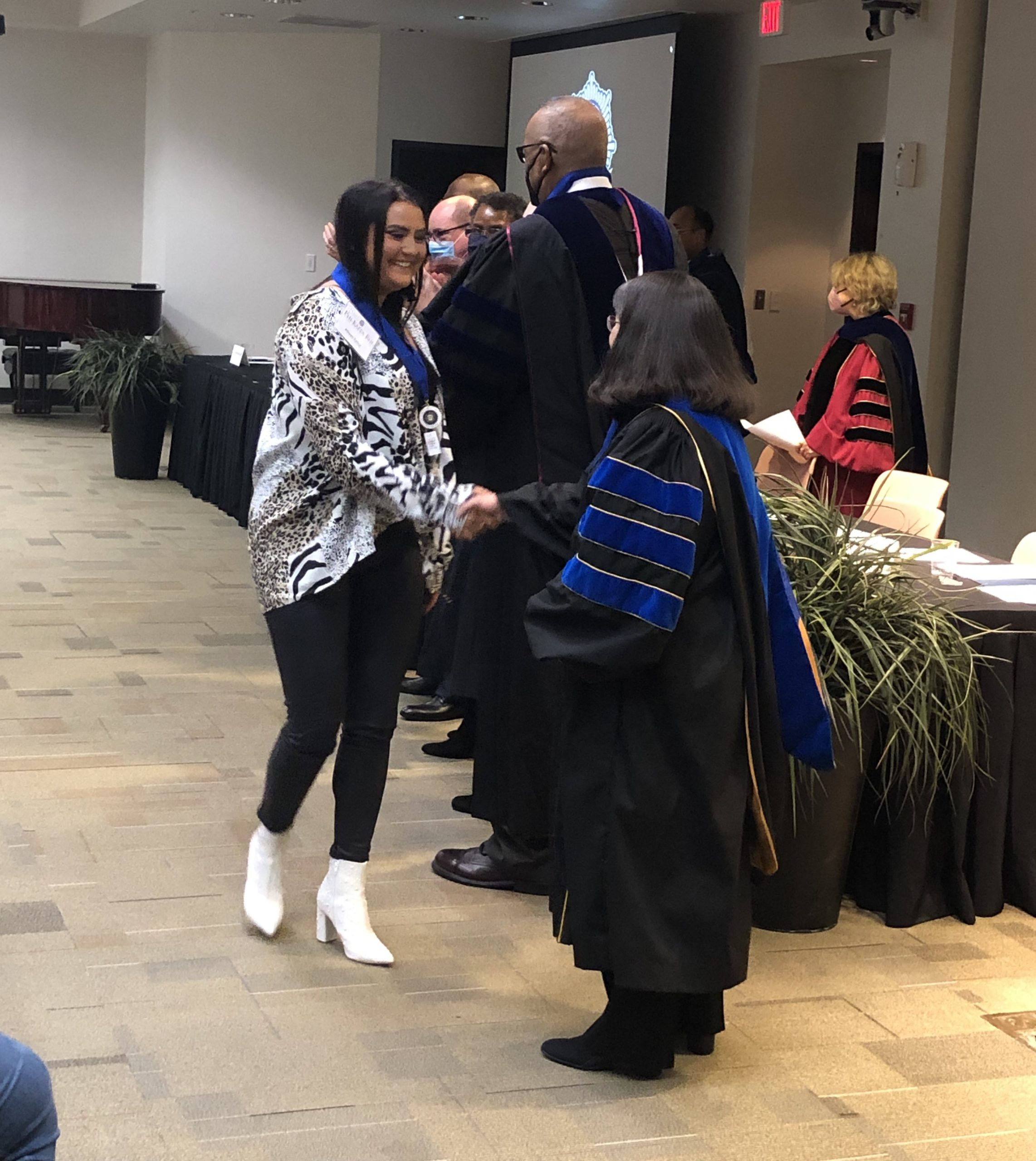 Chancellor Christina Drale congratulates a UA Little Rock student inducted into Phi Kappa Phi on Dec. 3.