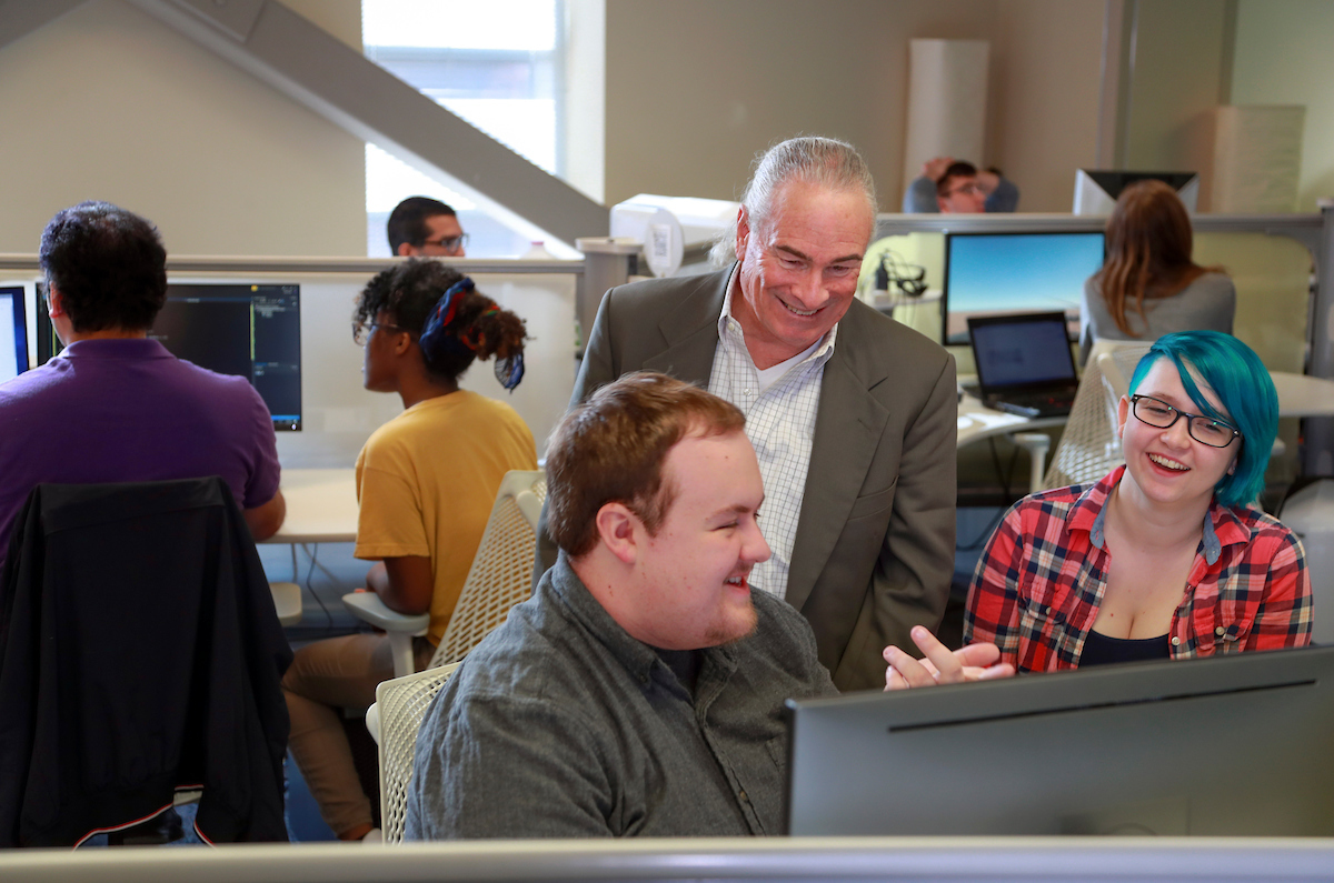 Dr. Albert Baker, chair of the Department of Computer Science, works with students in the Emerging Analytic Center. Photo by Ben Krain.