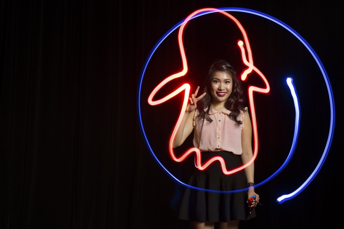 UALR alumna and artist Cyrene Quiamco draws an image with flashlights