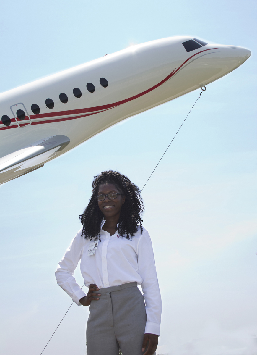 Brittany Wright stands in front of a model Falcon plane