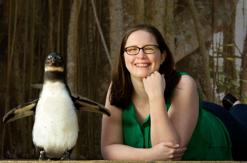 Jessica Erwin poses with a penguin at Little Rock's zoo. Photo by Lonnie Timmons III