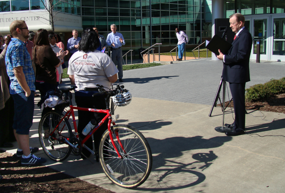 A group gathers outside the Student Services Center as Chancellor Joel Anderson speaks in front of them.