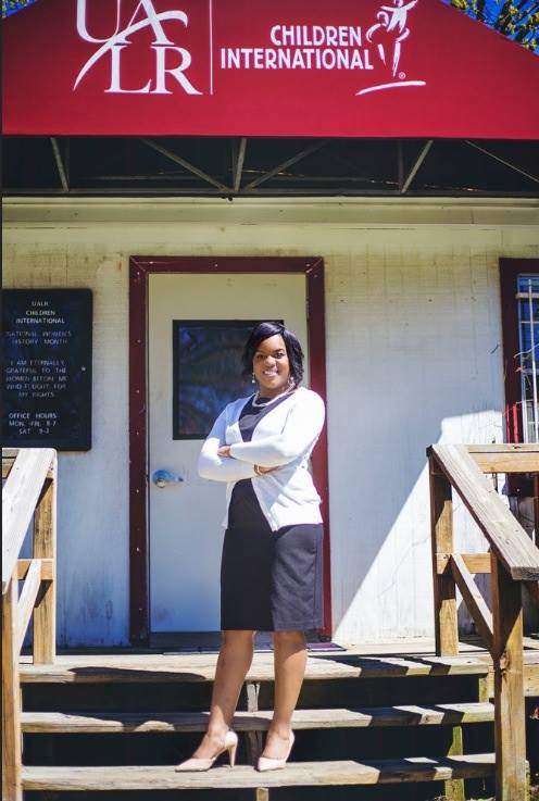 Talethe Collins stands in front of UALR Children International.