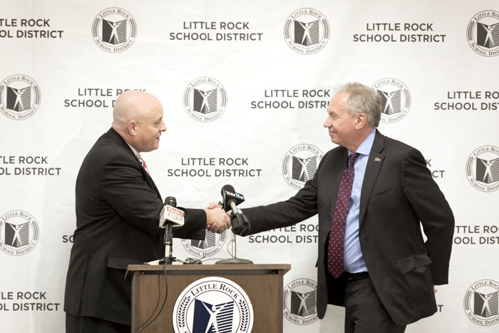 Little Rock School District Superintendent Michael Poore, left, and University of Arkansas at Little Rock Chancellor Andrew Rogerson greet during an announcement of a new Trojan Pathway partnership on Dec. 13, 2016.