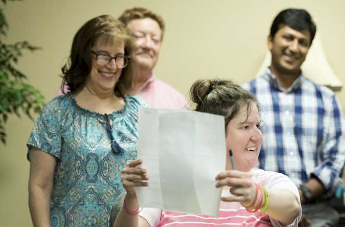 Charlee Brosh, a student in the UA Little Rock/Easterseals Arkansas Academics, Community, Career Development and Employment Program, signs an offer letter to work as a clinical technician in the UAMS Audiology and Speech Pathology Clinic. Photo by Lonnie Timmons III/UA Little Rock Communications.