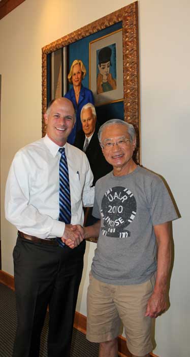 Christian O'Neal, vice chancellor for university advancement, shakes hands with Rising Star Workshop Director Yupo Chan in front of the portrait of the Baileys in the Bailey Alumni Center.