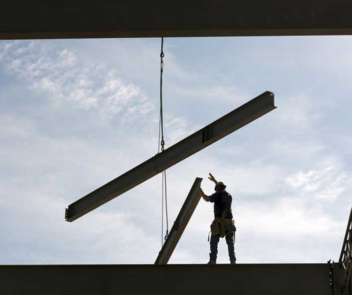 An iron worker handles an iron beam during the construction of the Windgate Center of Art + Design building at UA Little Rock. Photo by Lonnie Timmons III/UA Little Rock Communications.
