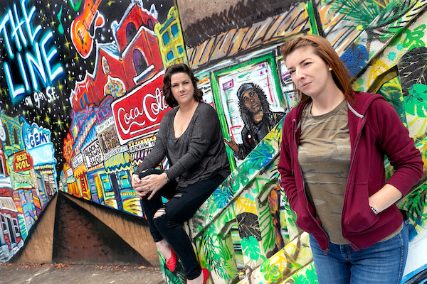 UA Little Rock students Nicole Stewart, left, and Talia Winkler are contributing their artistic talent to paintings on the 7th Street Peace Mural in Little Rock. Photo by Ben Krain.