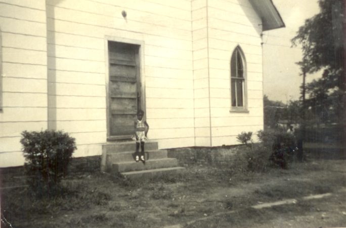Girl standing in front of Pilgrim Rest Missionary Baptist Church #3, one of the cornerstones of the Westrock community. Credit: Lois Threet