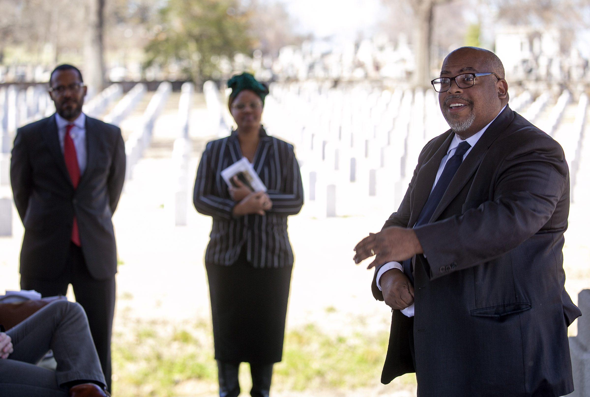 Brian Mitchell, middle, talks about the significance of an historic marker for Frank Moore, a member of the Elaine 12, placed March 6 in Little Rock National Cemetery. Photo by Ben Krain.