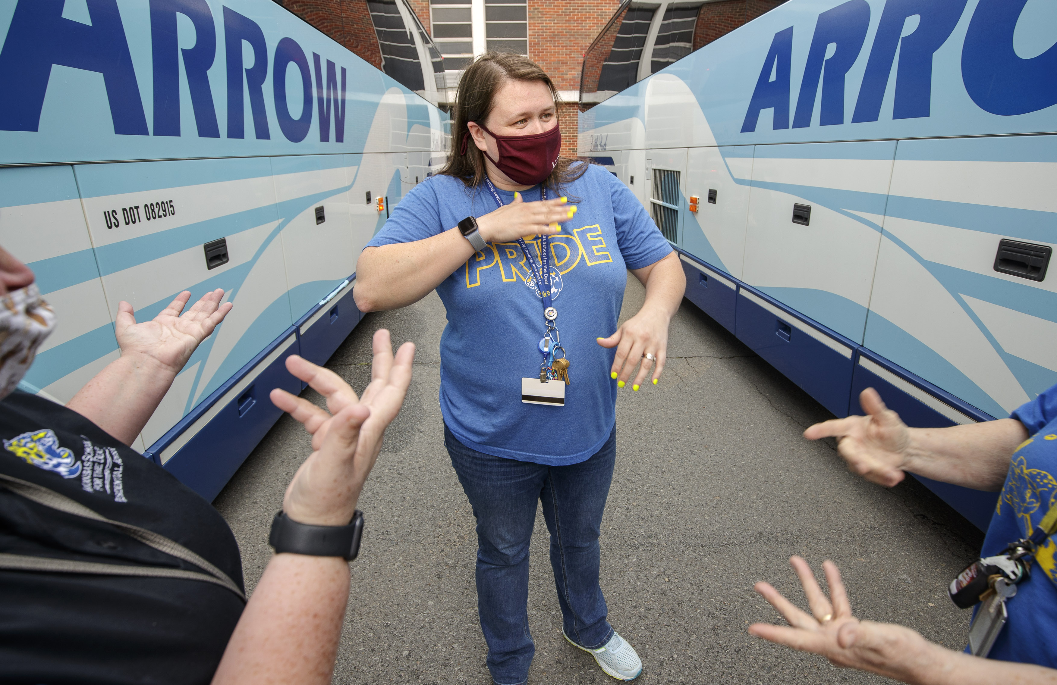 Jennifer Blanks communicates in sign language to other staff members at the Arkansas School for the Deaf about boarding students onto buses before the school’s weekend dismissal. Photo by Ben Krain.