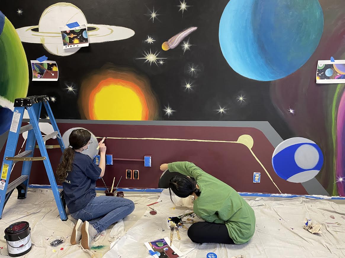 UA Little Rock students work on a mural in the Donaghey Student Center gaming lounge.