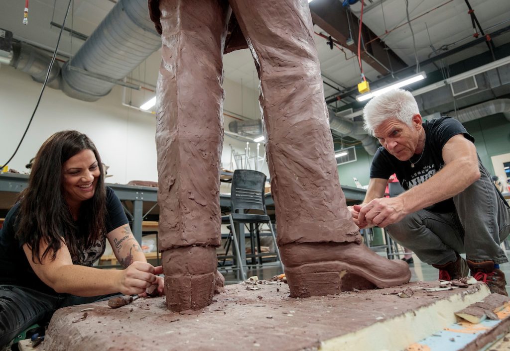 UA Little Rock alum Kevin Kresse, right, and assistant Nicole Stewart, left, work on a clay model of Arkansas music legend Johnny Cash at the Windgate Center of Art + Design from which a bronze statue will be cast. 