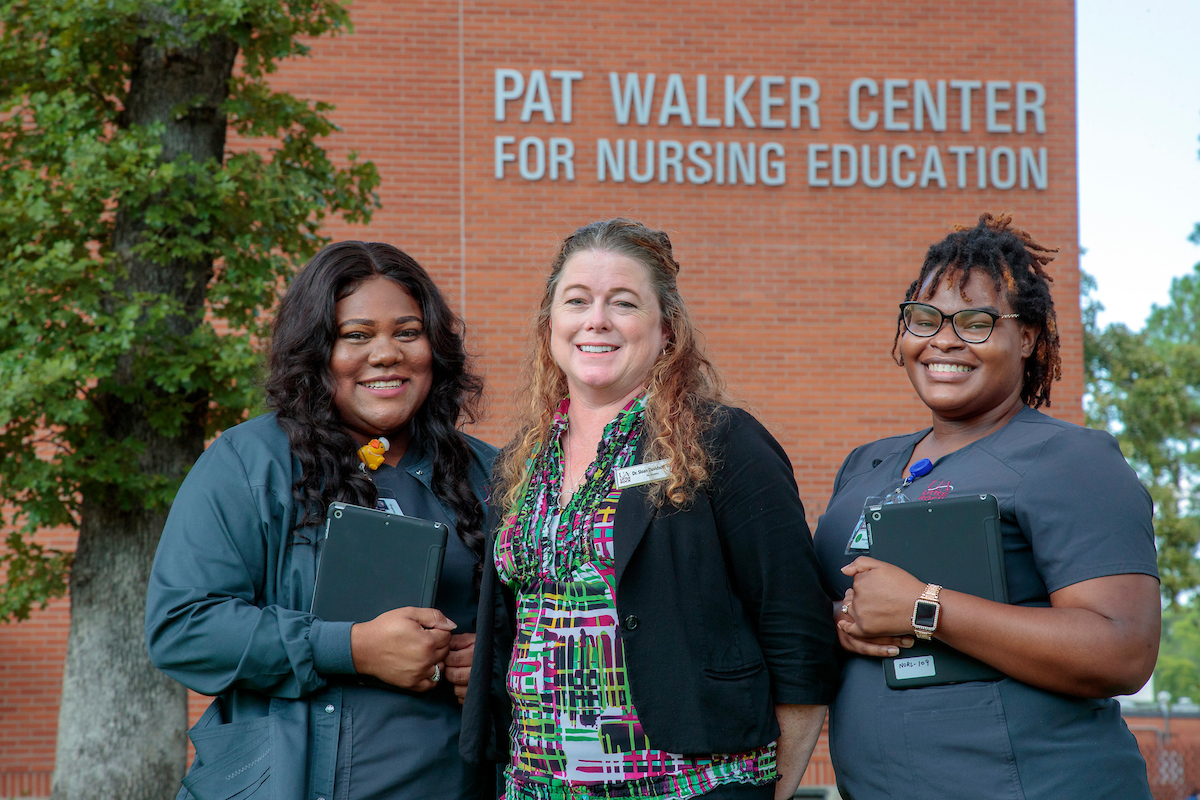 Nursing students stand in front of the Pat Walker Center for Nursing Education at UA Little Rock. Photo by Ben Krain.