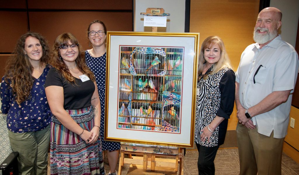 Members of the UA Little Rock Art + Design program pose with scholarship recipient Annika Wade, second from left, and scholarship donor Leslie Shellam, second from right. An original painting by Arkansas artist and philanthropist Linda Blaine Flake was donated to the UA Little Rock by Flake’s daughter, Leslye Shellam, during a panel discussion on how art and business are connected and the importance of philanthropy in supporting students in both fields.