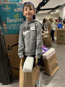 Joanna Hall's son Bodie  delivers donations to families at the Family Assistance Center. 