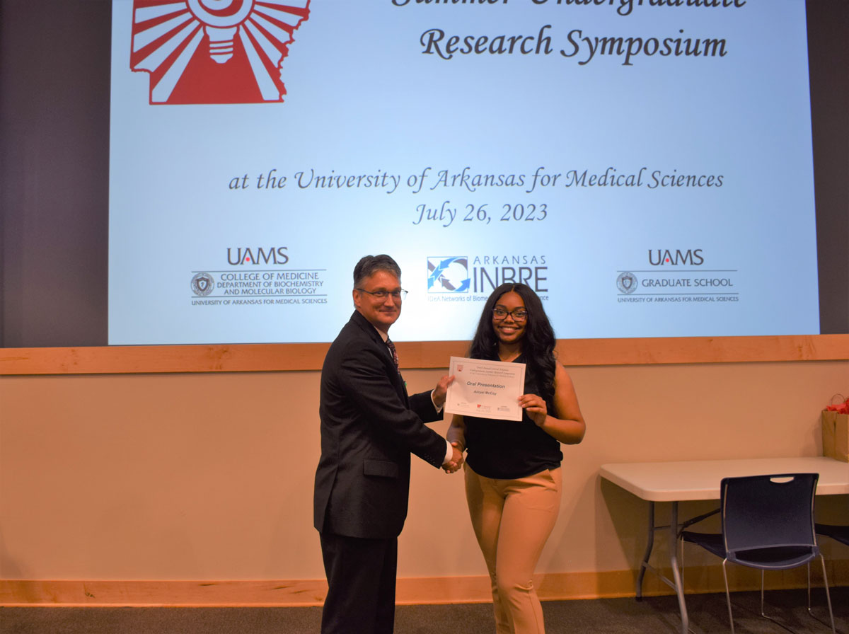 UA Little Rock student Aiiryel McCoy receives a certificate for presenting during the 10th Annual Arkansas Undergraduate Summer Research Symposium at UAMS.