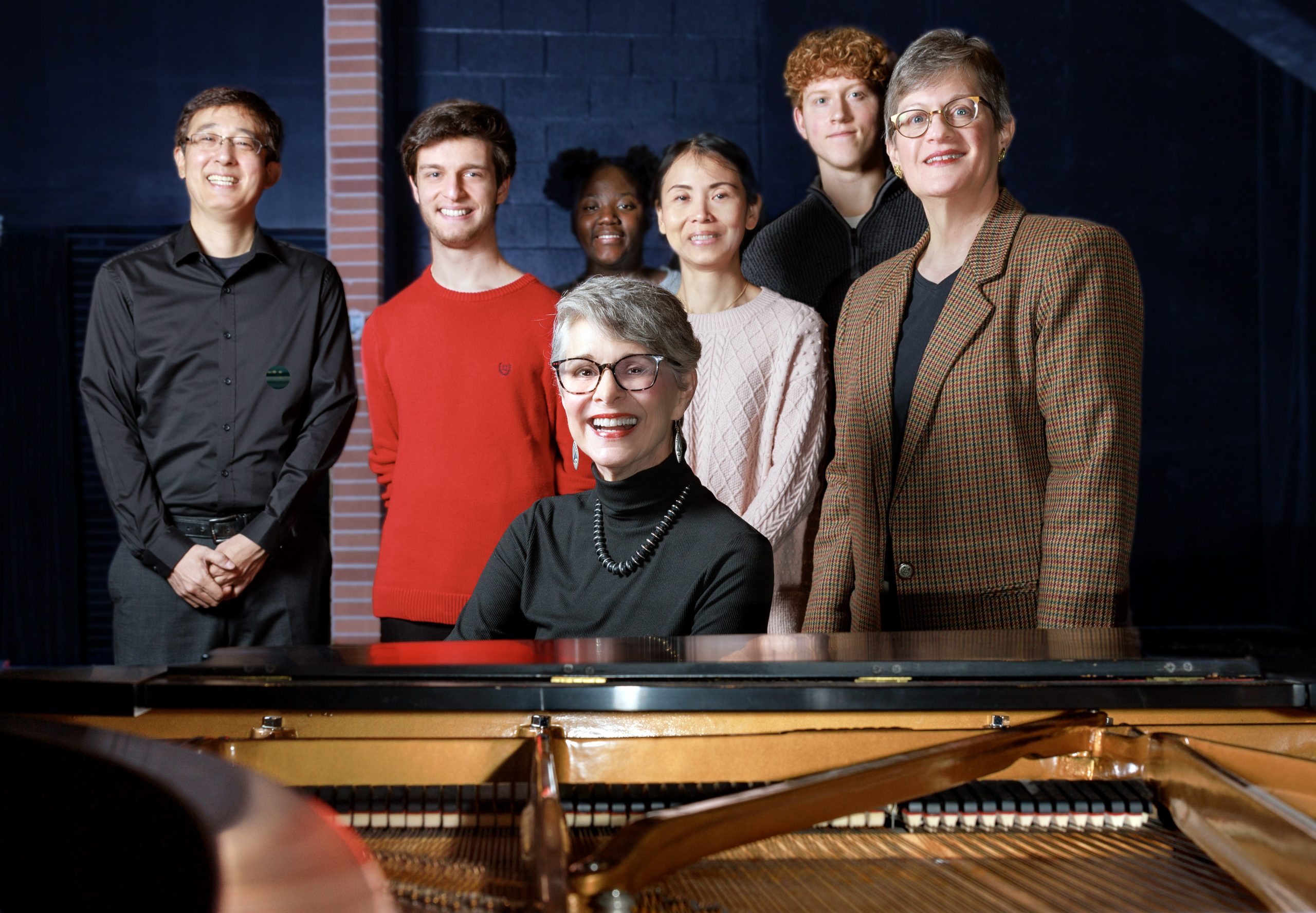 Donor Jeanette Hamilton, center, plays the piano surrounded by UA Little Rock music faculty and students, from left to right, Dr. Naoki Hakutani, Stephen Graham, Nakira Bates, Rachel Tsai Ashton Blankenship, and Dr. Linda Holzer. Photo by Ben Krain.