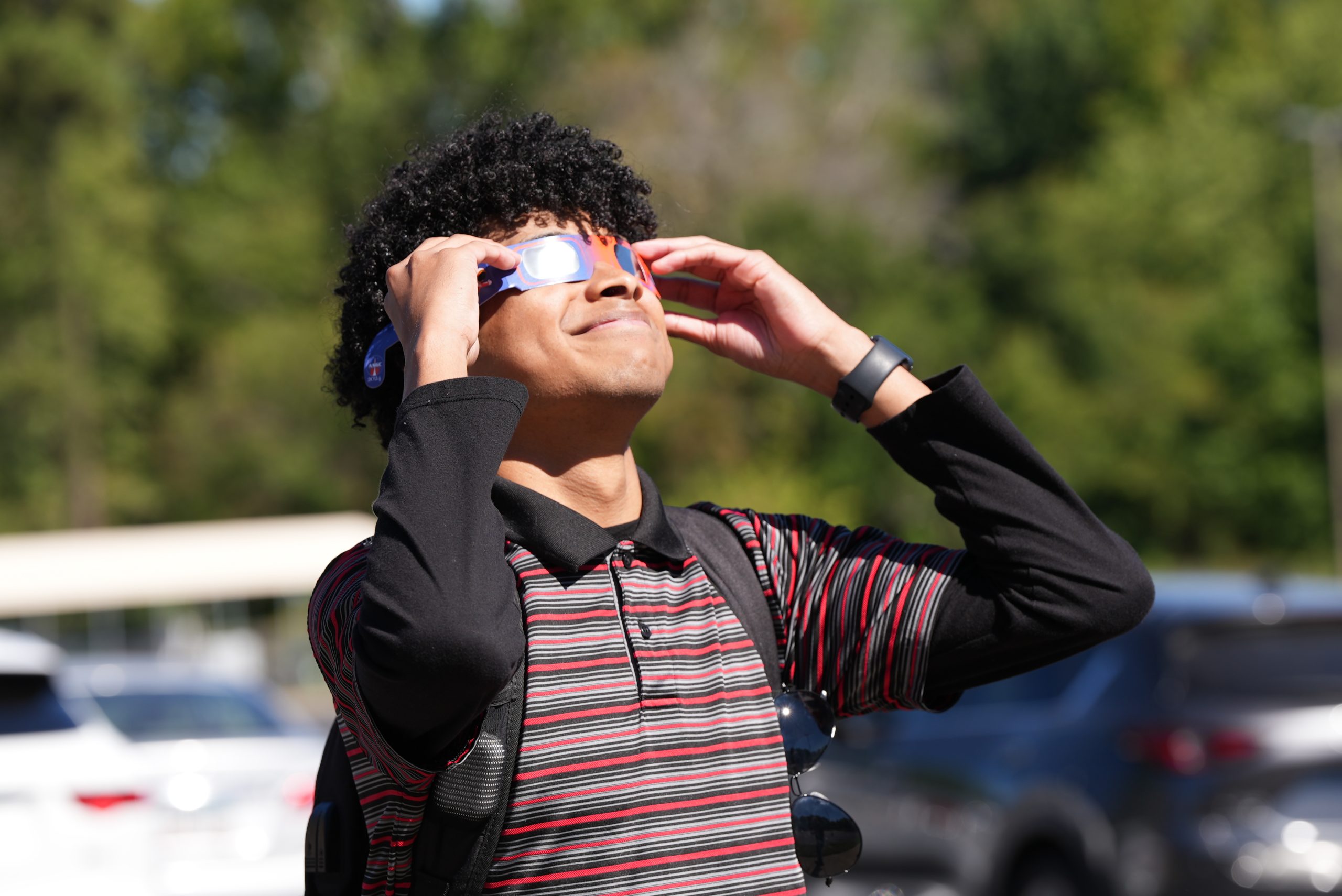A UA Little Rock student uses eclipse glasses to view a solar eclipse.