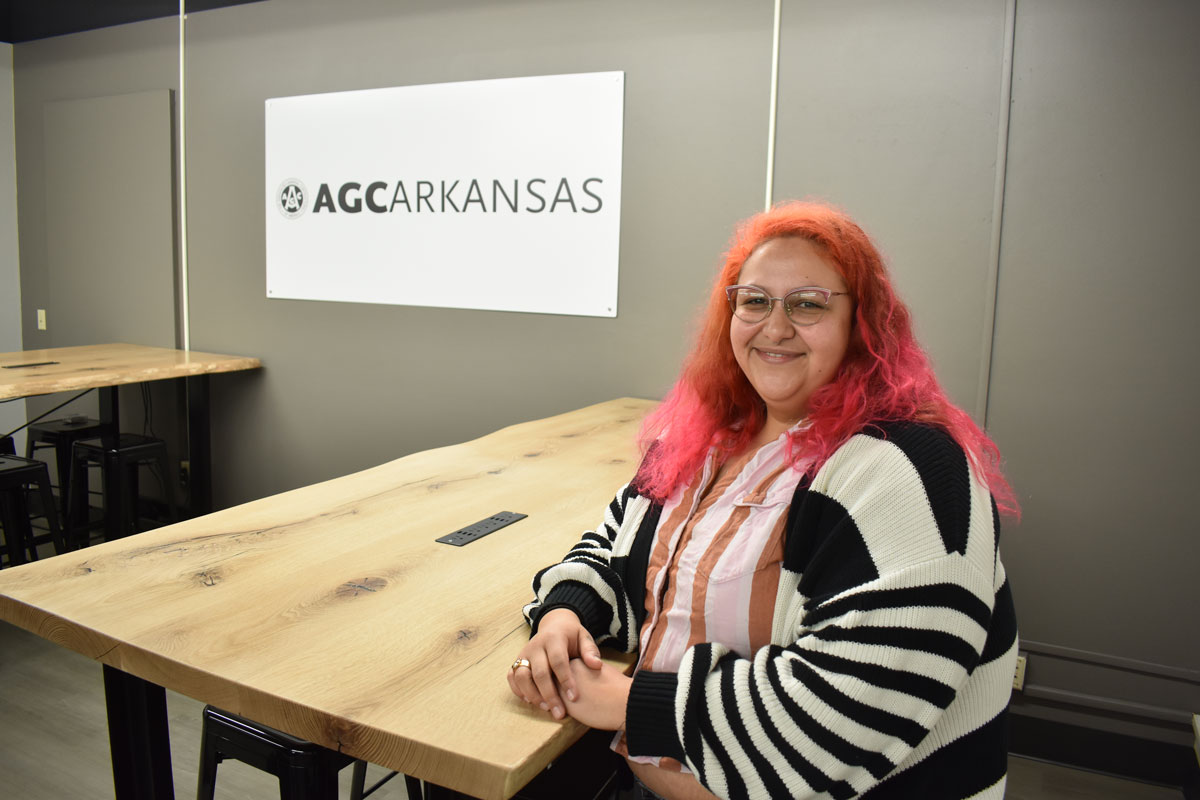 UA Little Rock student Kim Arcega sits at the custom table she created for a new student lounge sponsored by the Associated General Contractors of Arkansas. Photo by Jen Adams.