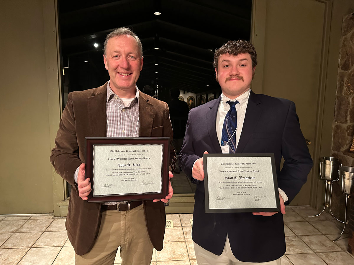 Dr. John Kirk and Scott Bradshaw, a public history student at UA Little Rock, show off their awards from the Arkansas Historical Association.
