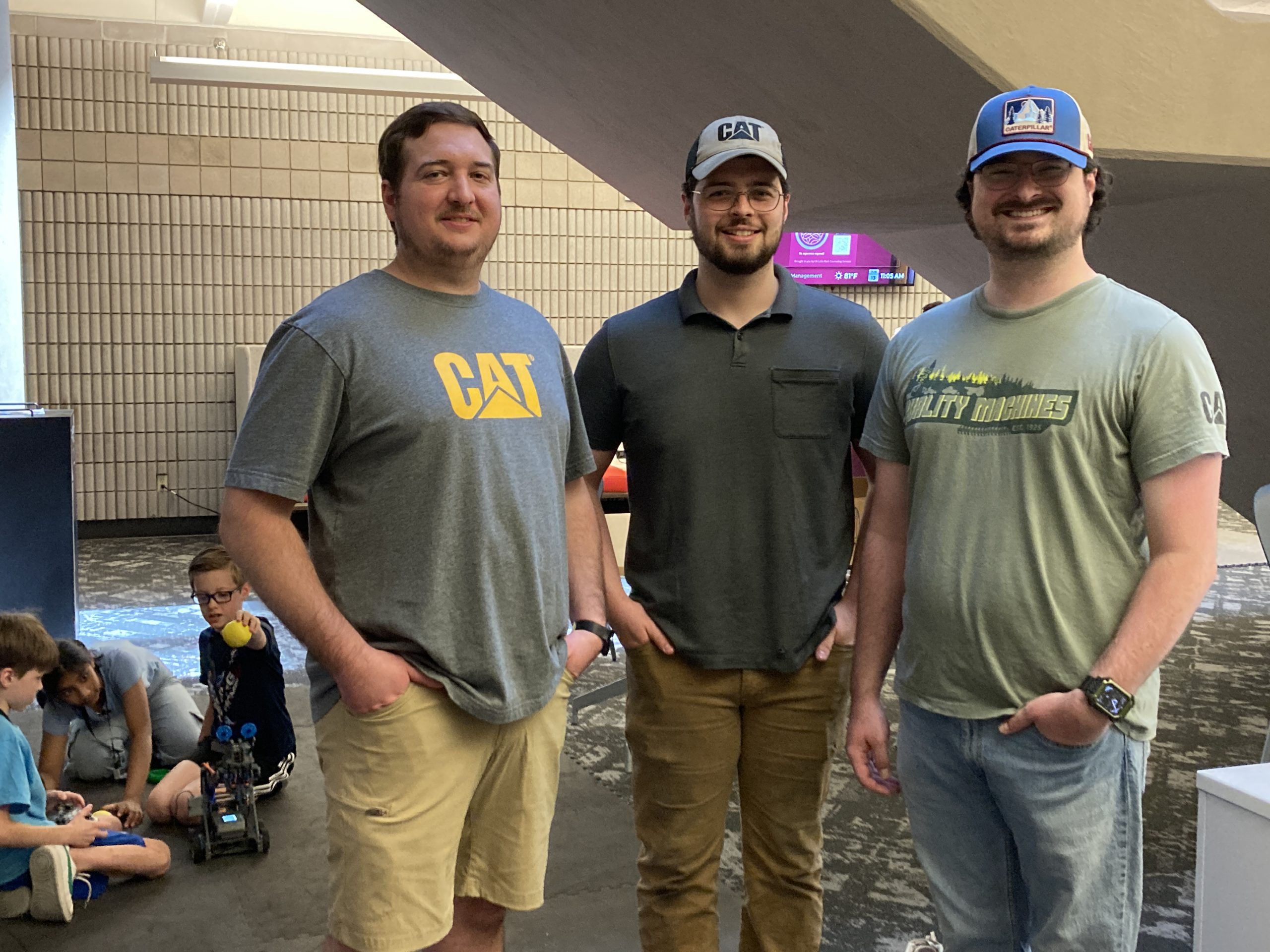 Three Caterpillar employees who participate in Caterpillar Young Professionals, an employee outreach group, spent June 13 volunteering with students learning about robotics.