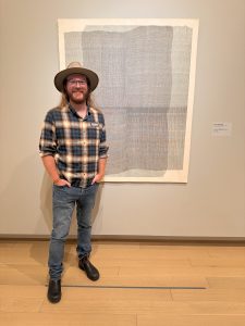 Clark Valentine is shown with his work, Untitled (Weaving 7), on display in the Arkansas Museum of Fine Arts. 