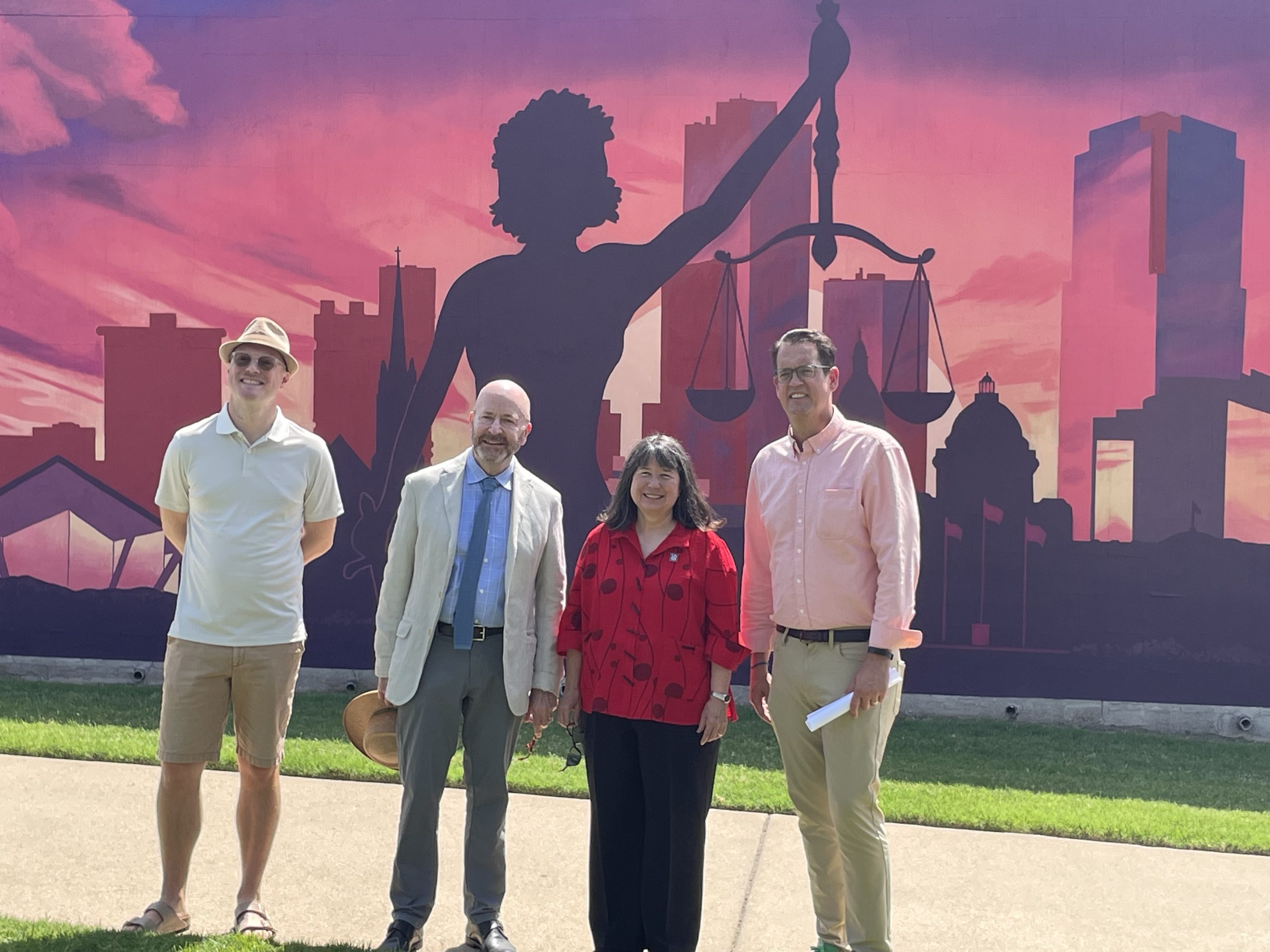 Officials celebrate the dedication of the new "Lady Justice" mural at the William H. Bowen School of Law. From left: Mural Artist Joel Boyd, Bowen Dean Colin Crawford, UA Little Rock Chancellor Christina Drale, and Gabe Holmstrom, executive director of the Downtown Little Rock Partnership.