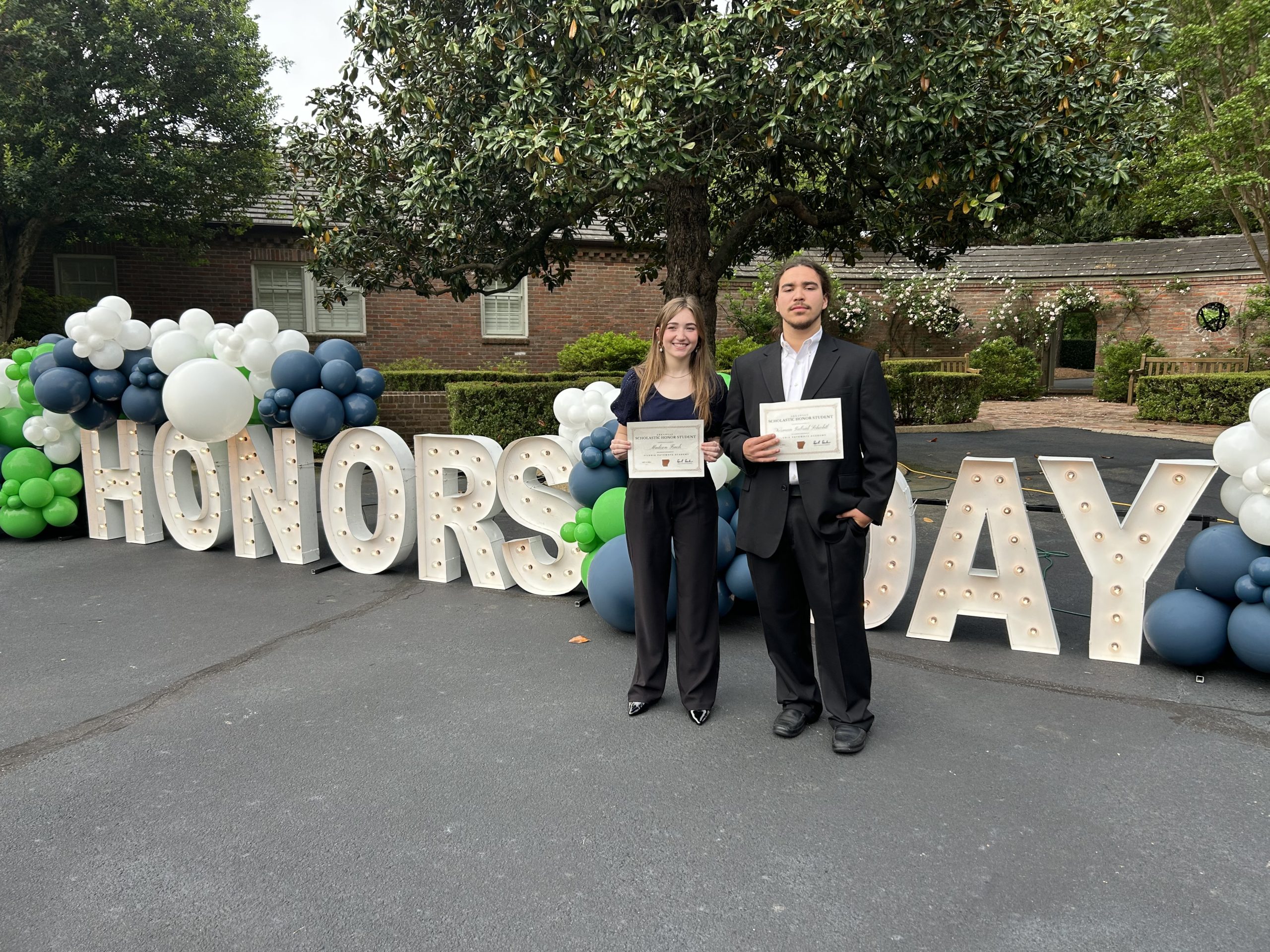 Madison Finch, left, and her classmate, Gabe Schichtl, right, celebrate their graduation from Vilonia Pathways Academy.