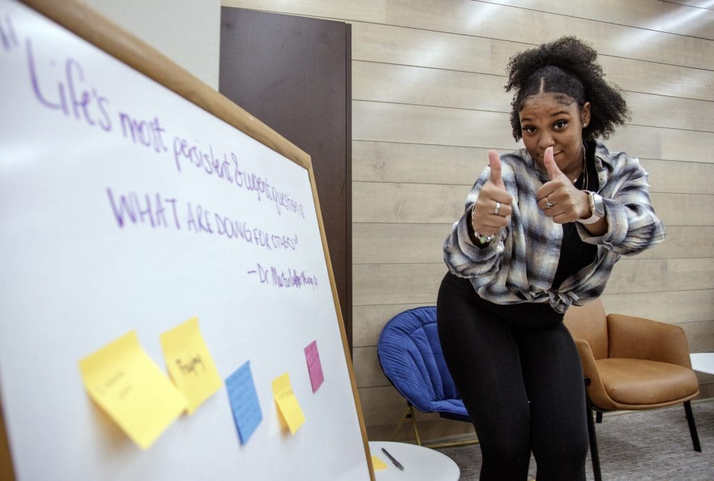 Students put sticky notes with their answer to a quote from Dr Martin Luther King Jr. during an MLK Day of Service event held at the UA Little Rock Multi-Cultural Center.