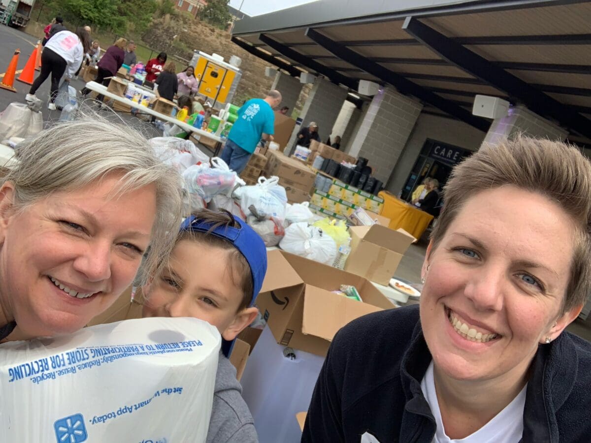 UA Little Rock nursing faculty Karen Bristow and Joanna Hall and her son Bodie volunteer at the Family Assistance Center.