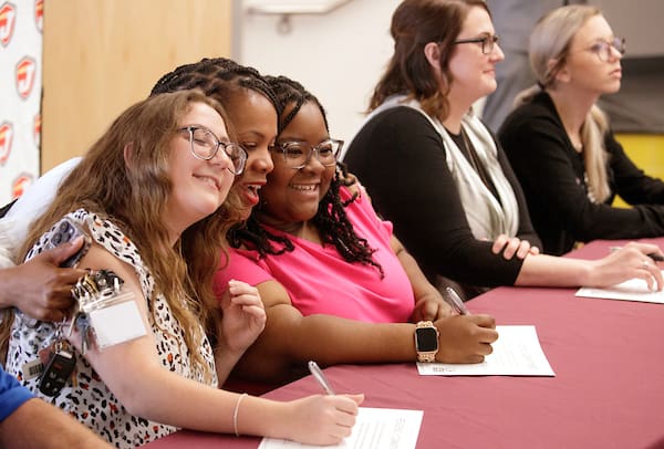 UA Little Rock education students participating in a new teacher residency program partnership between UA Little Rock and Jacksonville North Pulaski School District sign pledges. Photo by Benjamin Krain.