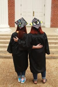 Mother and daughter graduates April Fitch and Caleigh Fitch Clayton show off their decorated graduation caps.
