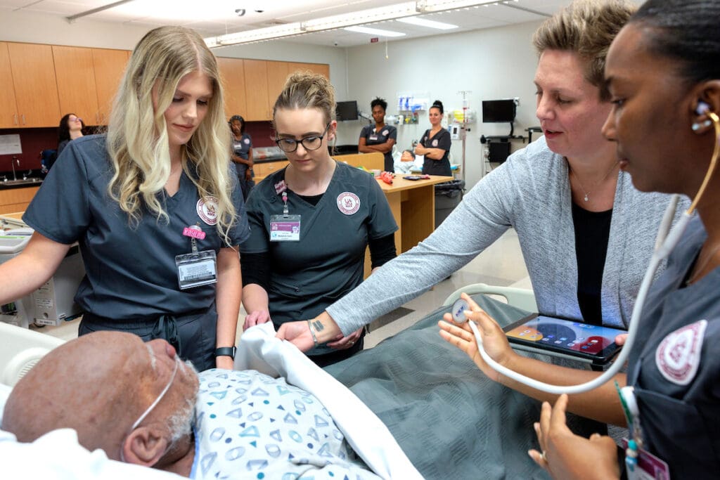 Joanna Hall, director of the Center of Simulation Innovation, assists UA Little Rock nursing students who received the Pat Walker Scholarship during a simulation in the Center for Simulation Innovation. Photo by Benjamin Krain.
