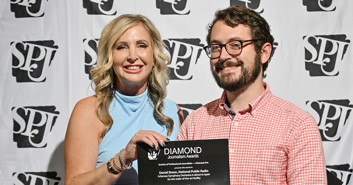 Little Rock Public Radio News Director Daniel Breen receives a Diamond Journalism Award from Heather Baker.