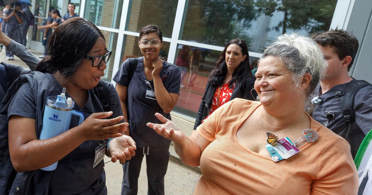 UA Little Rock nursing professor DeeDee Moline helps her students release her monarch butterflies after teaching a class in Dickinson Hall. Photo by Ben Krain.