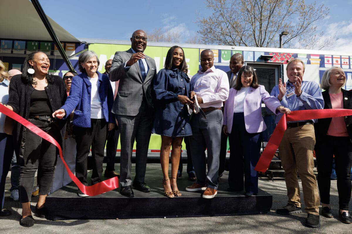Little Rock leaders line up to cut a ribbon to celebrate the opening of the new Mobile Market grocery store.
