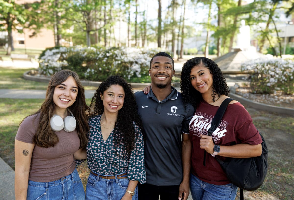 A diverse group of four UA Little Rock students pose for a photo.
