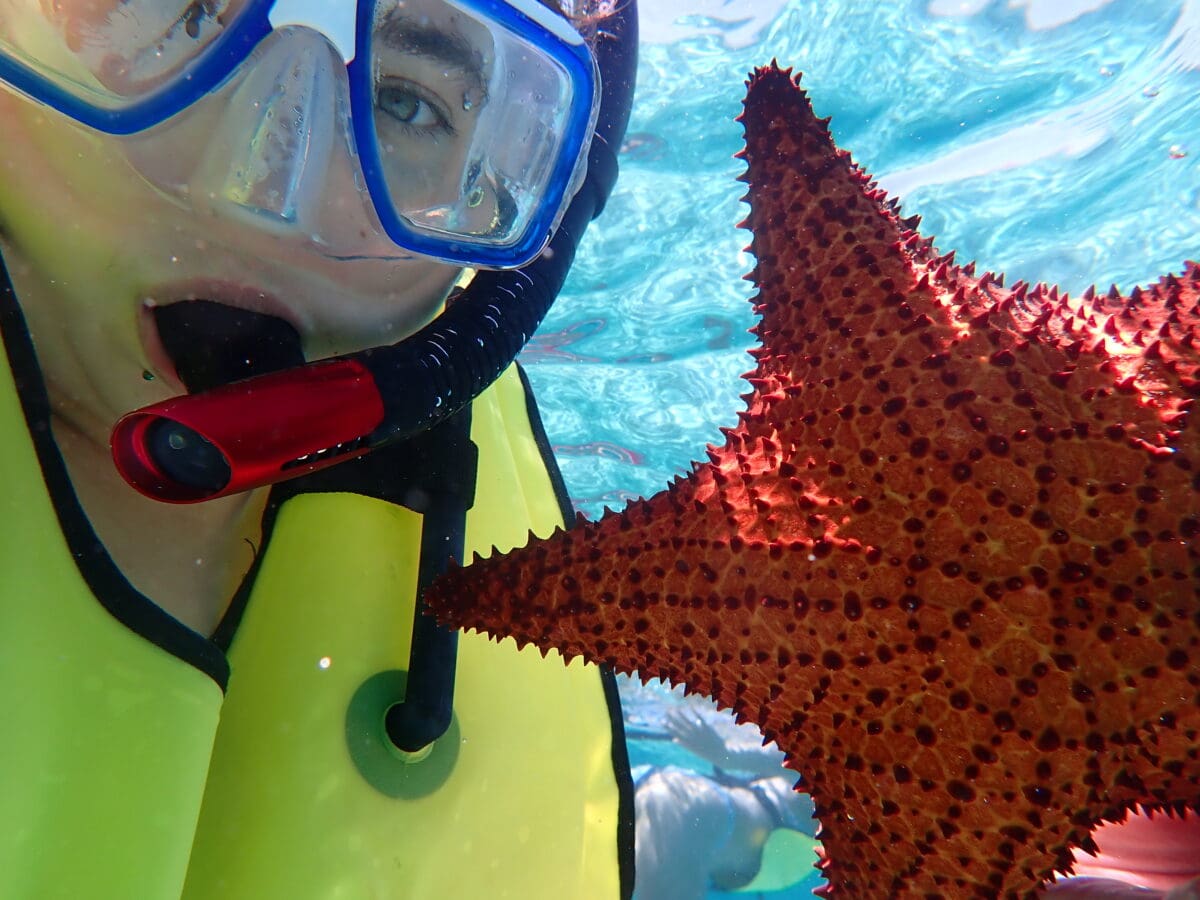 UA Little Rock student Syd Joheim with a starfish as part of her Study Abroad experience.