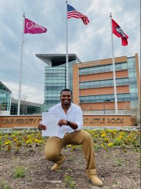 Evan Hicks poses in front of the Student Services Center at UA Little Rock