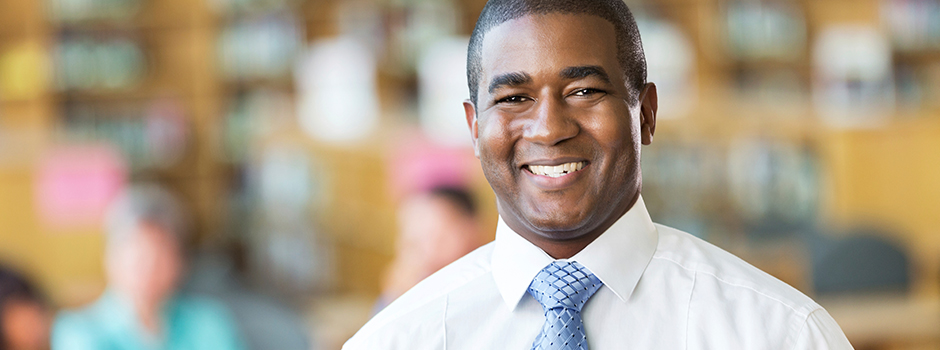 African American male in business attire smiling at the camera.