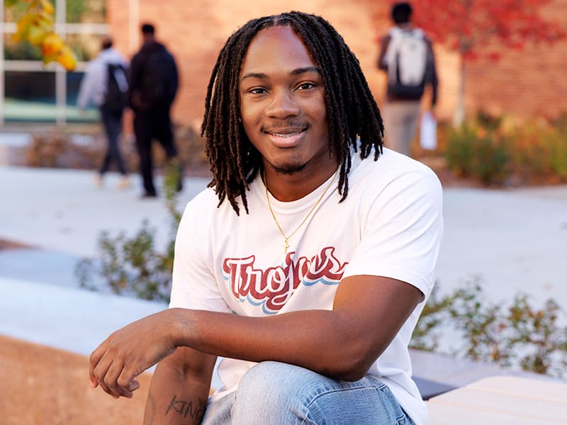 Male student sitting outside.